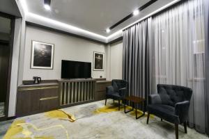a living room with two chairs and a flat screen tv at Bourbon Boutique Hotel in Yerevan +58 photos