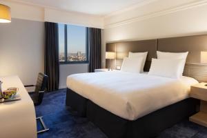 a hotel room with a large bed and a window at Pullman Paris Montparnasse in Paris