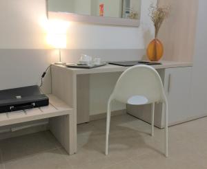 a white desk with a chair next to a laptop at Residenza DaMa in Lucera