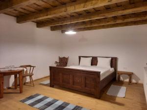een slaapkamer met een houten bed en een tafel bij Veseud11 in Veseud-Agnita