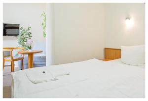 ein Hotelzimmer mit einem weißen Bett und einem Tisch in der Unterkunft Hotel & Restaurant Hähnel in Bannewitz