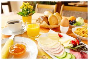 a table with breakfast foods and a cup of coffee at Hotel Hähnel in Bannewitz