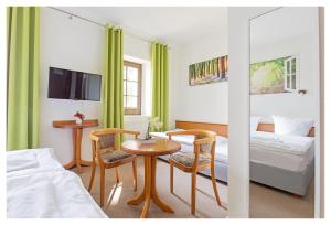 バンネヴィッツにあるHotel & Restaurant Hähnelのテーブル、椅子、ベッドが備わる客室です。