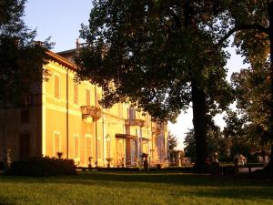 a large yellow building with a tree in front of it at Villa Cagnola in Varese