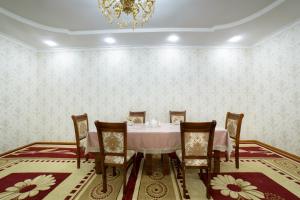 a dining room with a table and chairs and a chandelier at Sulaymon Guest House in Khiva