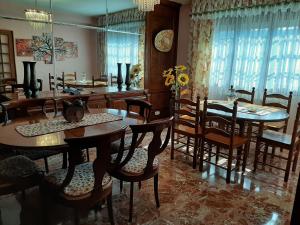 comedor con mesas y sillas de madera en Apartamento AS CARBALLAS, en Caldas de Reis