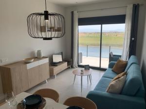 sala de estar con sofá azul y ventana grande en Casa Kadanza en Alhama de Murcia