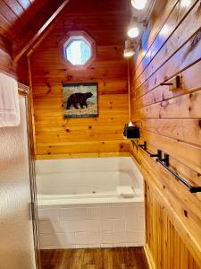 a bathroom with a bath tub in a wooden wall at Beary Charming Hottub Great Location 4 Miles to Gatlinburg in Gatlinburg +9 photos