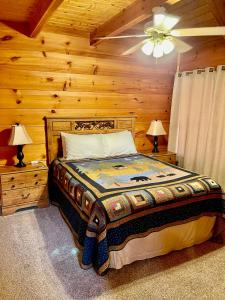 a bedroom with a bed and a ceiling fan at Beary Charming Hottub Great Location 4 Miles to Gatlinburg in Gatlinburg