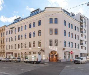 a large white building with cars parked in front of it at Schönbrunn Palace Beautiful 1 bedroom apartment in Vienna