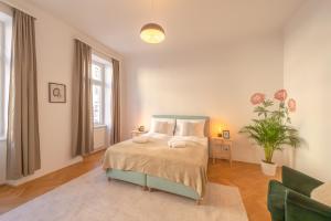 ein Schlafzimmer mit einem Bett und einer Topfpflanze in der Unterkunft Schönbrunn Palace Beautiful 1 bedroom apartment in Wien
