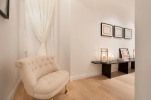 a living room with a white chair and a table at Apartments Florence - Federighi in Florence