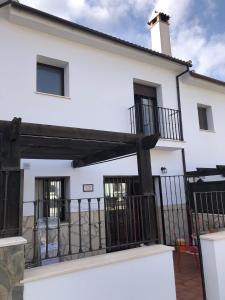 埃爾博斯克的住宿－LA CASITA DE EL BOSQUE，白色的房子,有黑色的围栏