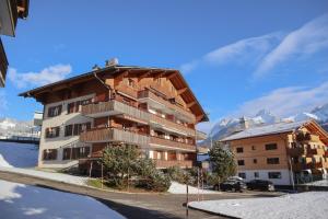 un grand immeuble avec des montagnes en arrière-plan dans l'établissement Appartement Ancien Comté, à Château-d'Oex