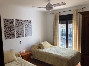 a bedroom with two beds and a ceiling fan at LA CASITA DE EL BOSQUE in El Bosque