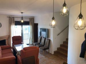 a living room with a couch and chairs and lights at LA CASITA DE EL BOSQUE in El Bosque