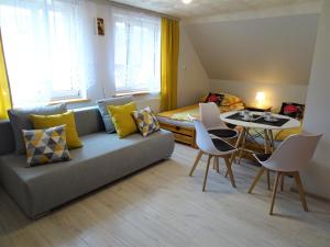 uma sala de estar com um sofá, uma mesa e uma cama em Pokoje u Danusi em Sromowce Niżne