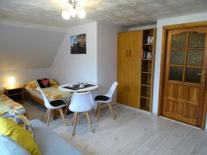 a living room with a table and chairs and a bed at Pokoje u Danusi in Sromowce Niżne