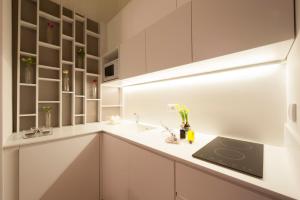a kitchen with white cabinets and a sink at Apartments Florence - Federighi in Florence