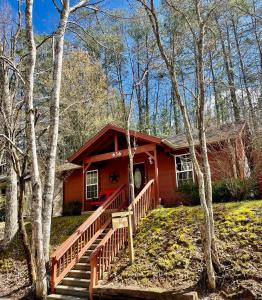 a small red house with a staircase in the woods at Beary Cuddly in Gatlinburg