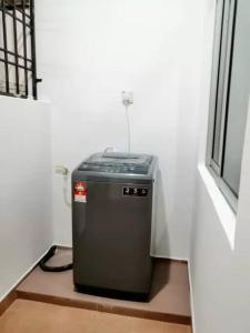 a small refrigerator sitting in a room next to a window at Bukit Indah Nearby Aeon Issix 4 rooms up to 8 pax in Johor Bahru