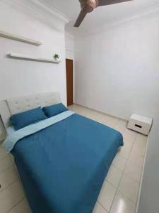 a bedroom with a blue bed in a white room at Bukit Indah Nearby Aeon Issix 4 rooms up to 8 pax in Johor Bahru