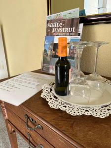 eine Flasche Wein und Gläser auf dem Tisch in der Unterkunft Ferienwohnung Am Anger in Naumburg