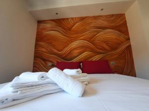 een bed met handdoeken en een houten hoofdeinde bij WiSaRelax in Brusciano