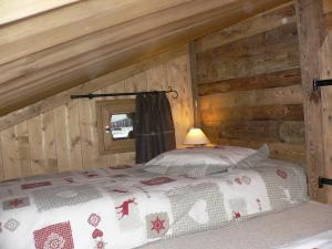 um quarto com uma cama num chalé de madeira em Petit chalet individuel de caractère em Megève
