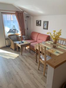 ein Wohnzimmer mit einem rosa Sofa und einem Tisch in der Unterkunft Allgäustüble in Steibis