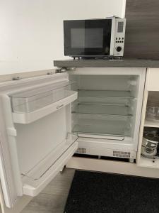 
a white refrigerator in a kitchen next to a microwave at Studio Kristof 705 in Westende
