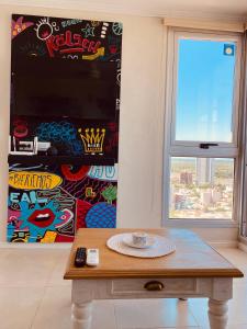 - Mesa de centro en una habitación con ventana en Exclusivo Departamento en piso 20 sobre Bv Gálvez, cochera y piscina en Santa Fe