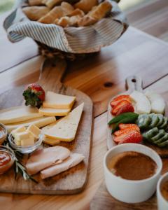 a table with cheese and bread and a bowl of dip at Furnas Lake Forest Living in Furnas