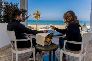 a man and woman sitting at a table with a bottle of wine at EUROPA Hotel in Vasto