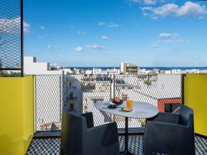a table on a balcony with a view of the city at 3 Pines Design Living in Heraklio