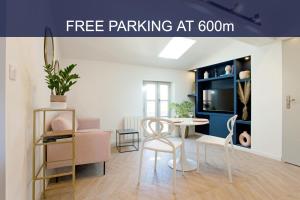 a living room with a table and chairs in a room at La Nuit Arlésienne - Exclusive apartments in Arles