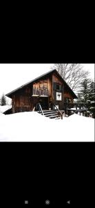 a wooden cabin with snow in front of it at Chalet Baluma Maluba in Jahorina
