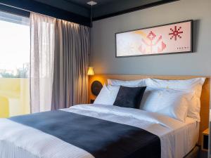 Un dormitorio con una cama grande y una ventana. en 3 Pines Design Living, en Heraclión