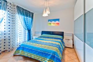 1 dormitorio con 1 cama con manta azul y amarilla en Residence Caravelle, en Caorle