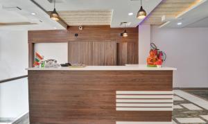 a kitchen with wooden cabinets and a counter top at Itsy By Treebo - Royal Galaxy in Jahāngīrābād