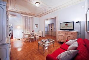 フィレンツェにあるApartments Florence - Ghibellina 96のリビングルーム(赤いソファ、テーブル付)