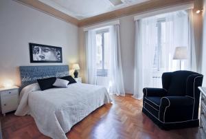 フィレンツェにあるApartments Florence - Ghibellina 96のベッドルーム1室(ベッド1台、椅子、窓付)