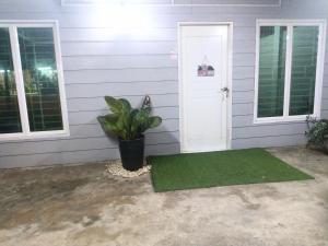 a house with a green rug next to a door at Azie Homestay in Kota Bharu +2 photos