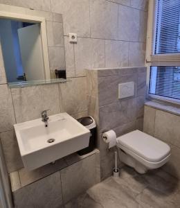 a bathroom with a sink and a toilet at Hotel Linda in Gladbeck