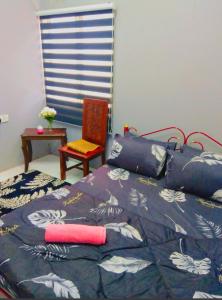 a bedroom with a bed with a blue comforter at Azie Homestay in Kota Bharu