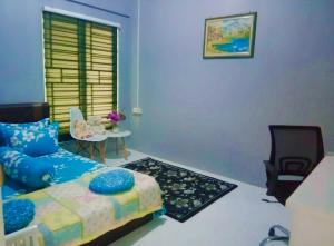 a living room with a couch and a chair at Azie Homestay in Kota Bharu