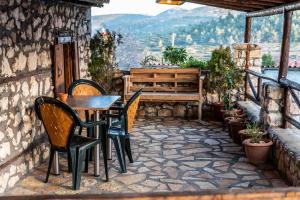 a patio with chairs and a table and a bench at Traditional Stone Guesthouse in Áyios Ioánnis