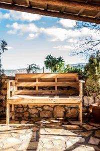 a wooden bench sitting on top of a stone wall at Traditional Stone Guesthouse in Áyios Ioánnis
