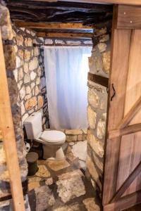 a stone bathroom with a toilet in a doorway at Traditional Stone Guesthouse in Áyios Ioánnis