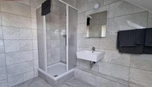 a bathroom with a white sink and a shower at Hotel Linda in Gladbeck